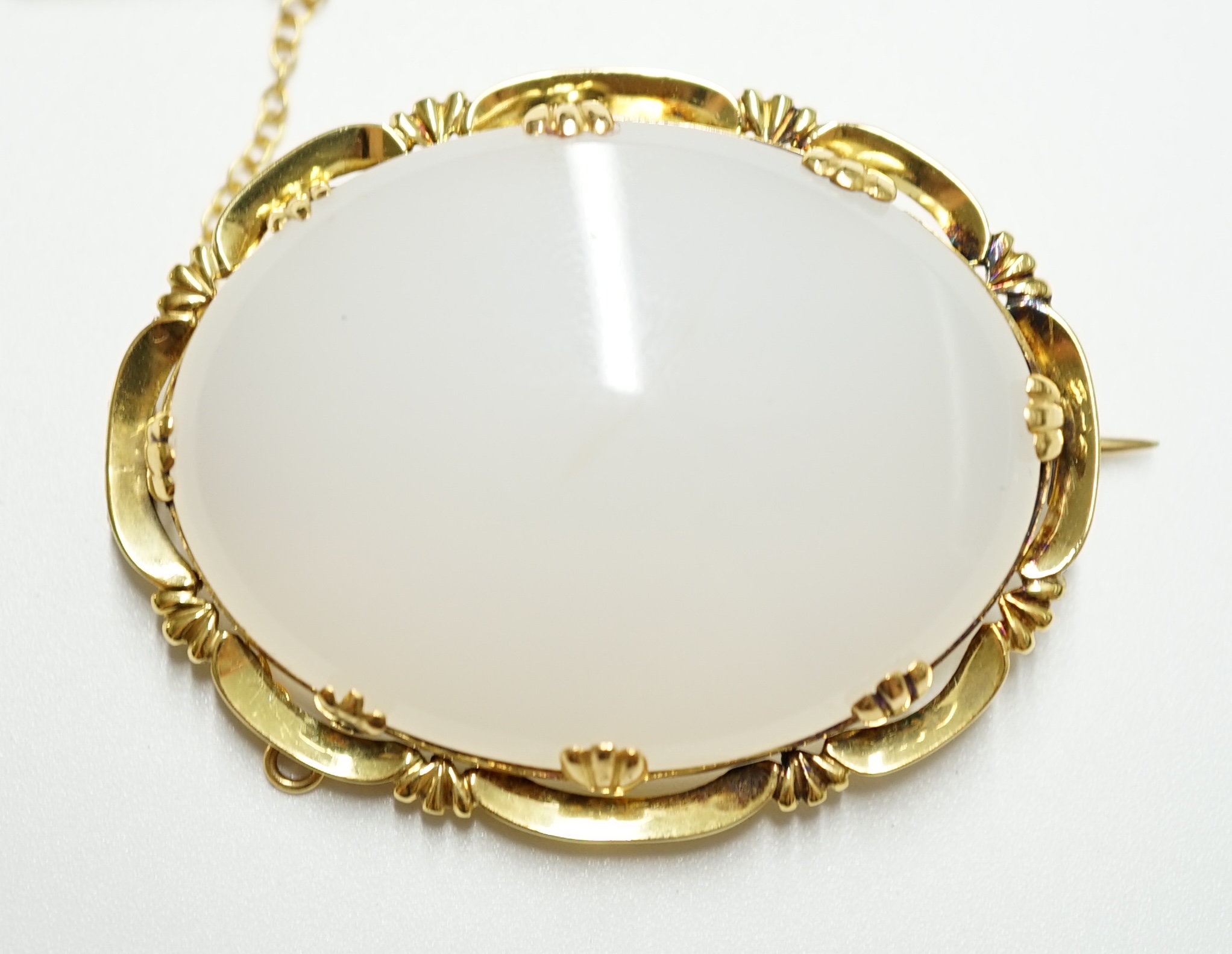 An early 20th century yellow metal mounted white chalcedony set oval brooch, 44mm, gross weight 19.6 grams. Condition - fair to good